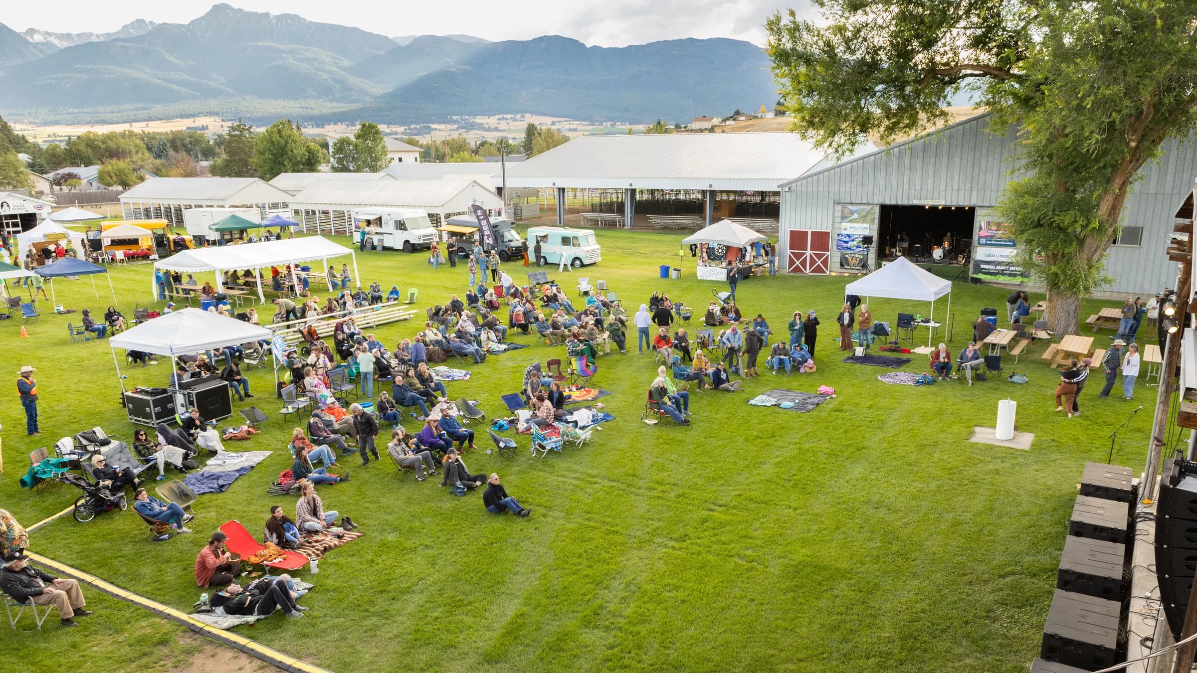 Blankets, tents and the main stage on the lawn at the Wallowa County Fairgrounds, late afternoon at Juniper Jam, September 5, 2026.