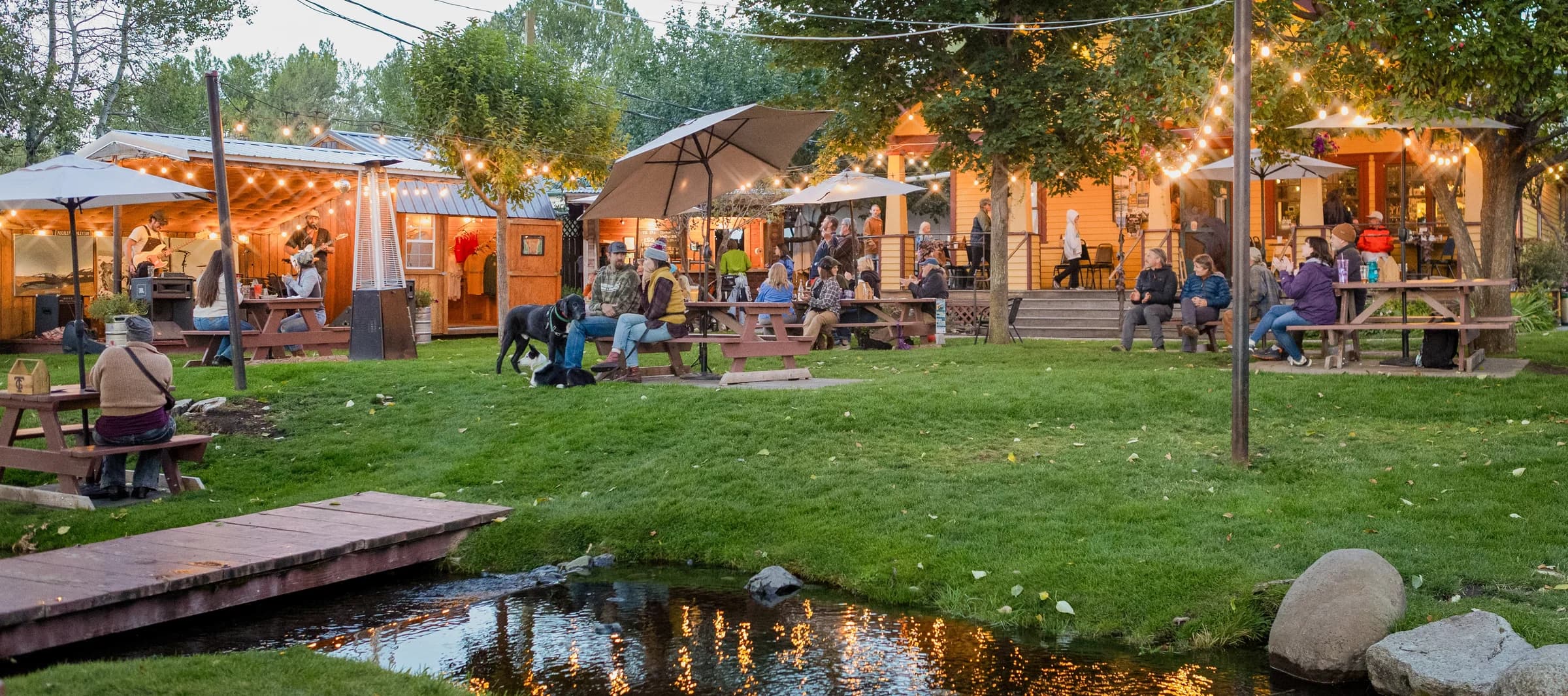 Terminal Gravity Brewing’s lawn at dusk, lights coming on over the picnic tables, during Rut Nut’s set on September 4, 2026.
